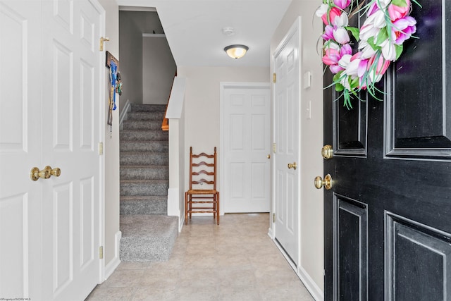 foyer with stairs and baseboards