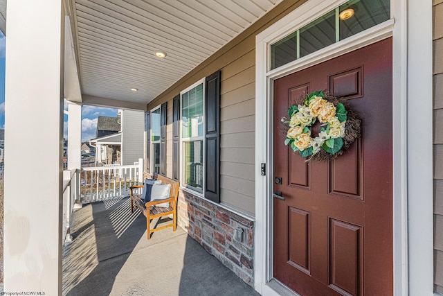 property entrance with covered porch and brick siding