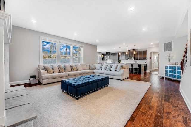 living room featuring arched walkways, dark wood-type flooring, visible vents, and recessed lighting