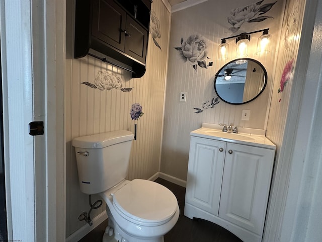 half bath featuring vanity, toilet, and baseboards