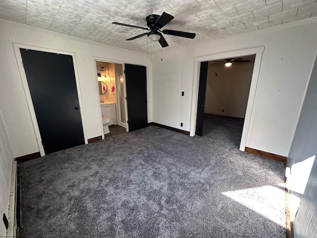 unfurnished bedroom featuring carpet floors, ensuite bathroom, baseboards, and a ceiling fan