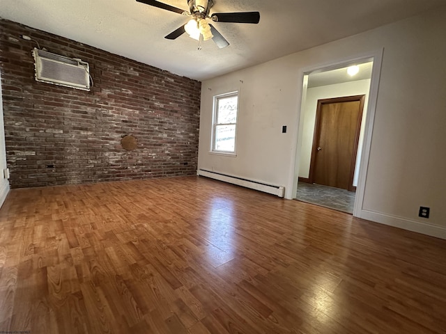 unfurnished living room with a textured ceiling, brick wall, a baseboard radiator, and wood finished floors