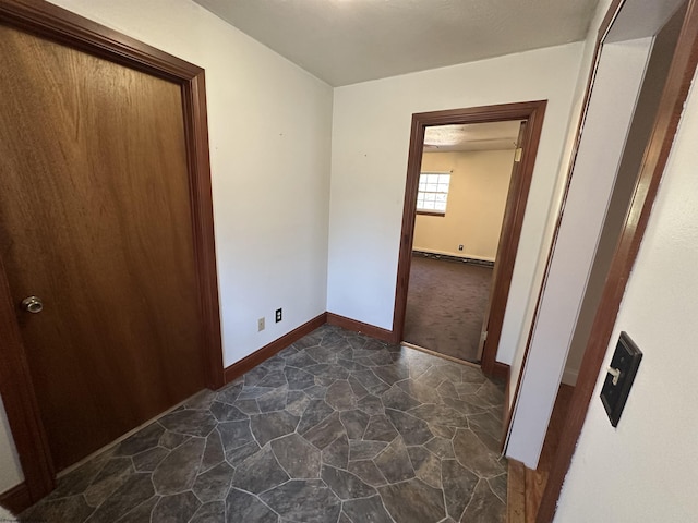 unfurnished bedroom featuring stone finish flooring and baseboards