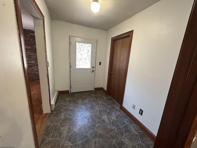 entryway with a baseboard radiator, baseboards, and stone finish flooring