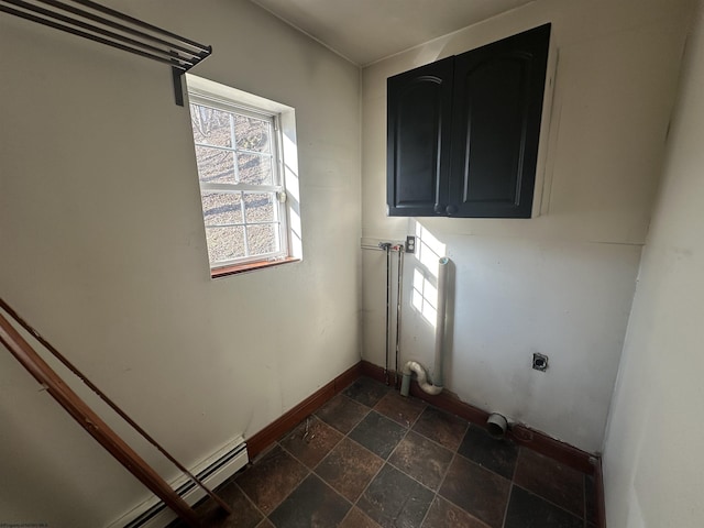 laundry area with baseboard heating, stone tile flooring, electric dryer hookup, and baseboards