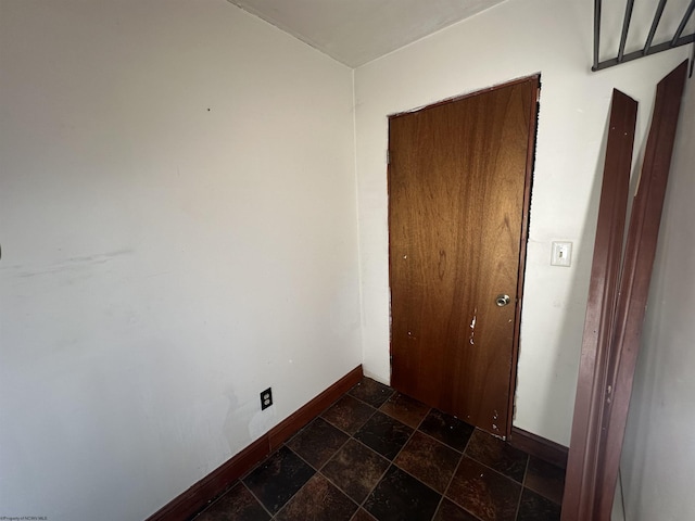 interior space with stone tile flooring and baseboards
