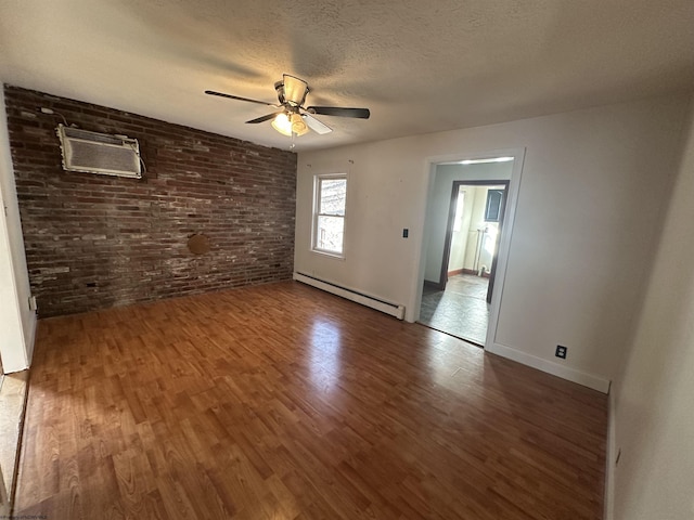 empty room with ceiling fan, wood finished floors, a wall mounted air conditioner, baseboard heating, and a textured ceiling