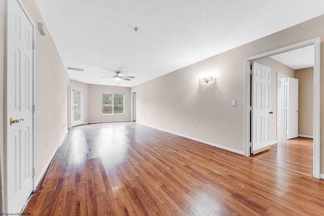 unfurnished living room with light wood-style flooring, baseboards, and ceiling fan