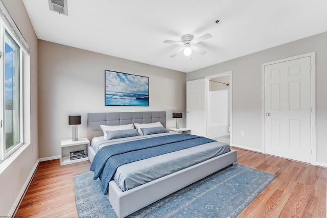 bedroom featuring a ceiling fan, visible vents, baseboards, and wood finished floors