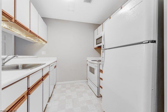 kitchen featuring light floors, light countertops, white cabinets, a sink, and white appliances