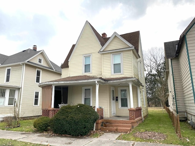 view of front of house with covered porch and a front yard