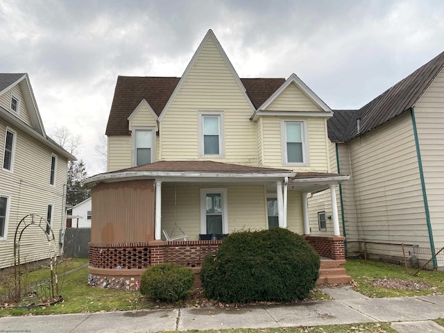 view of front of home with a porch and roof with shingles