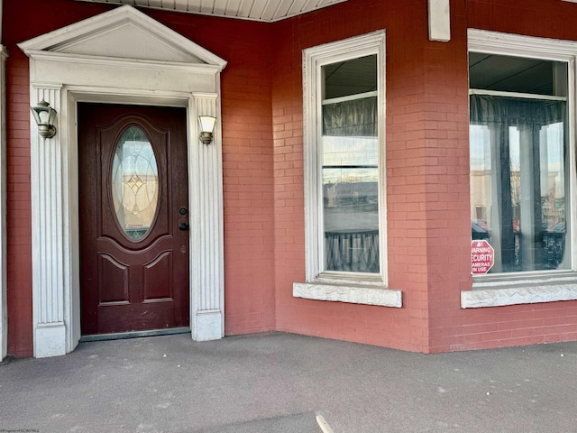 view of exterior entry featuring brick siding