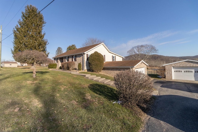 ranch-style home with a garage, brick siding, a front lawn, and aphalt driveway