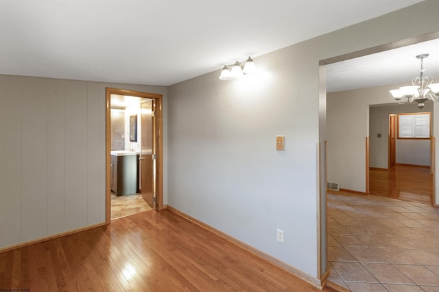 3508 Old Mill Rd, Weston, WV 26452 - spare room featuring light wood-type flooring, baseboards, visible vents, and a notable chandelier
