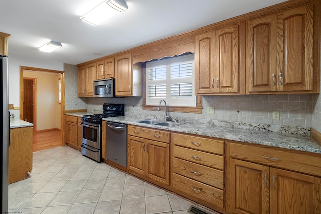 3508 Old Mill Rd, Weston, WV 26452 - kitchen featuring tasteful backsplash, appliances with stainless steel finishes, brown cabinetry, light tile patterned flooring, and a sink