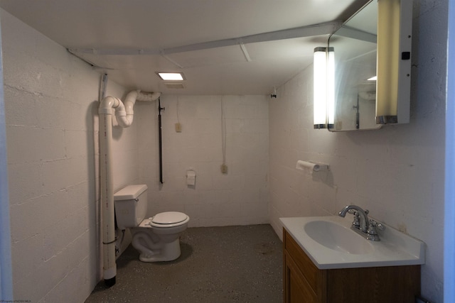 3508 Old Mill Rd, Weston, WV 26452 - bathroom with concrete flooring, concrete block wall, vanity, and toilet