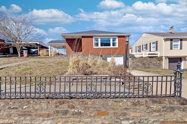 view of front facade with driveway, an attached garage, fence, and brick siding