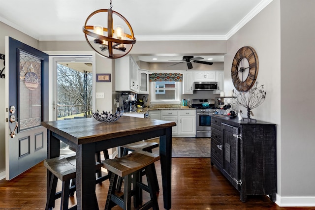 kitchen with appliances with stainless steel finishes, white cabinetry, dark wood finished floors, and crown molding