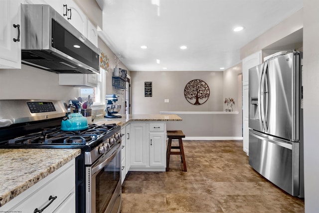 kitchen featuring baseboards, a peninsula, stainless steel appliances, a kitchen bar, and white cabinetry