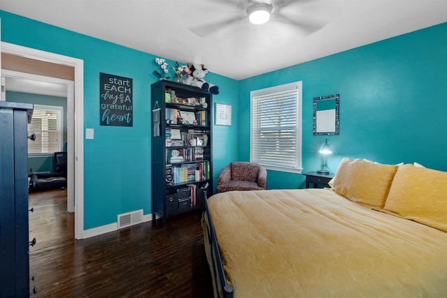 bedroom with visible vents, ceiling fan, baseboards, and wood finished floors