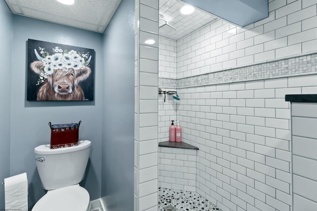 bathroom featuring tiled shower and toilet