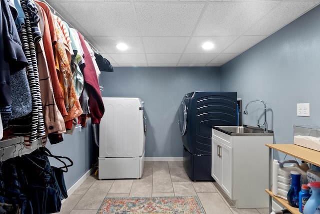 washroom with cabinet space, baseboards, separate washer and dryer, and a sink