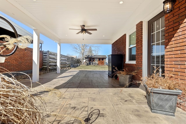 view of patio with fence and a ceiling fan