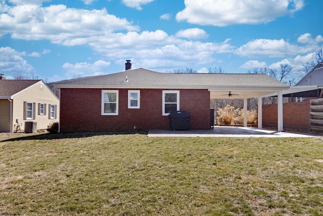 rear view of property featuring brick siding, a patio, a lawn, a ceiling fan, and cooling unit