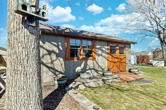 view of property exterior featuring roof with shingles and a yard