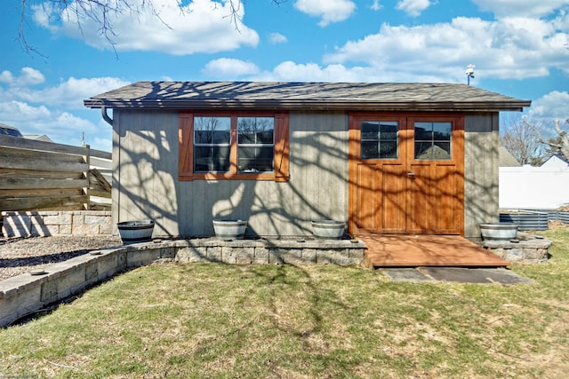 exterior space with fence, an outdoor structure, and a lawn