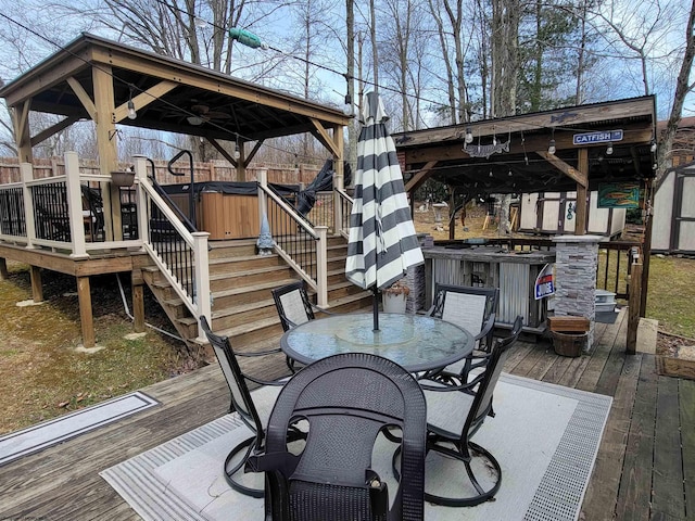 deck featuring a storage shed, an outbuilding, stairs, fence, and outdoor dining space