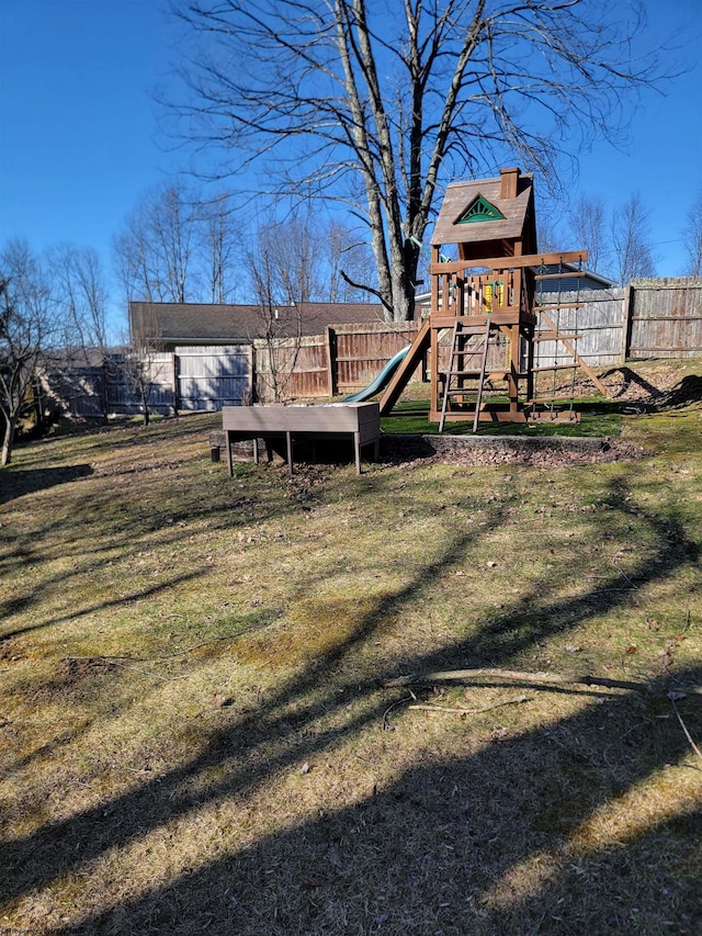 view of jungle gym with a lawn and fence