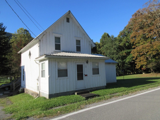 view of home's exterior featuring metal roof, a yard, and board and batten siding