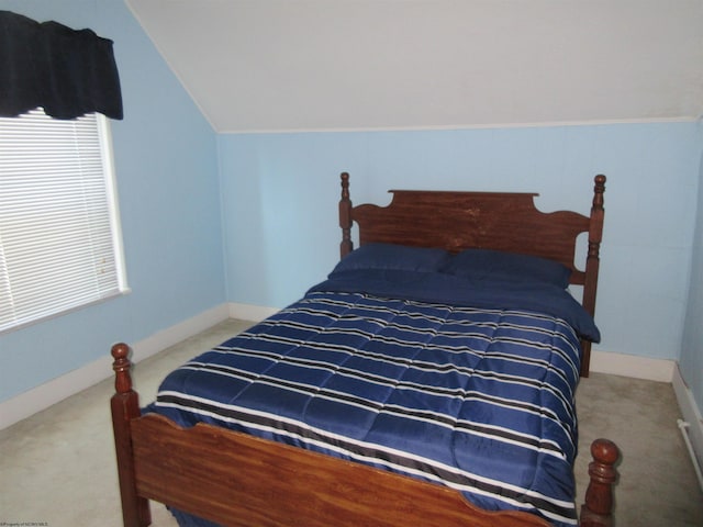 bedroom with baseboards, vaulted ceiling, and carpet flooring