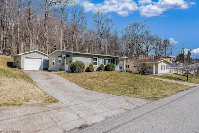 single story home featuring a detached garage, an outdoor structure, concrete driveway, and a front yard