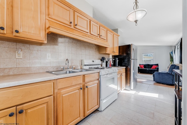 kitchen with light brown cabinets, a sink, light countertops, tasteful backsplash, and white gas range