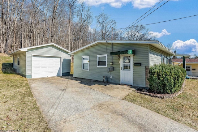 view of front of home with a front lawn, an outdoor structure, driveway, and a detached garage