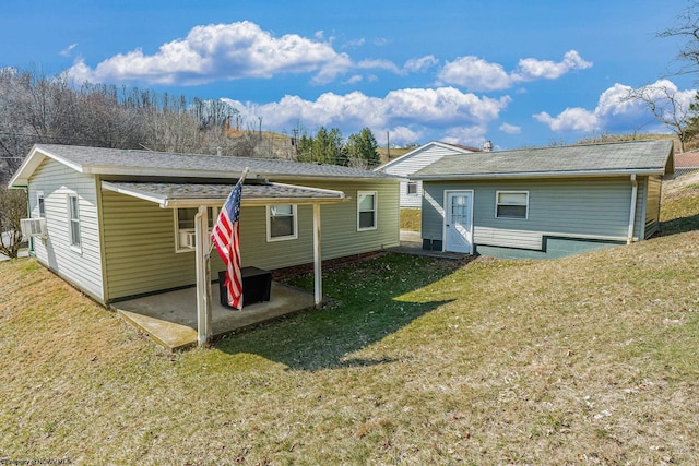 back of property with a yard, cooling unit, and a patio