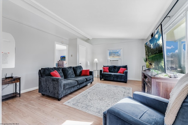 living area with lofted ceiling, arched walkways, light wood-style flooring, and baseboards