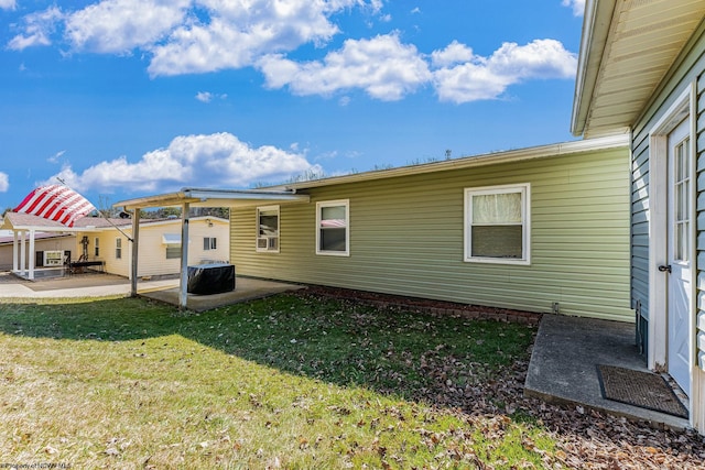 rear view of house featuring a yard, cooling unit, and a patio