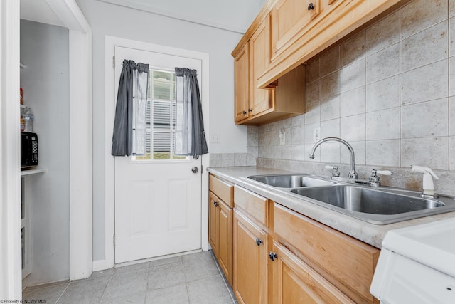 kitchen with tasteful backsplash, light countertops, a sink, and light tile patterned flooring