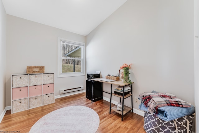 interior space featuring baseboards, a baseboard heating unit, vaulted ceiling, and wood finished floors