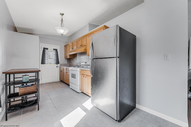 kitchen featuring baseboards, freestanding refrigerator, decorative backsplash, light brown cabinetry, and white gas range