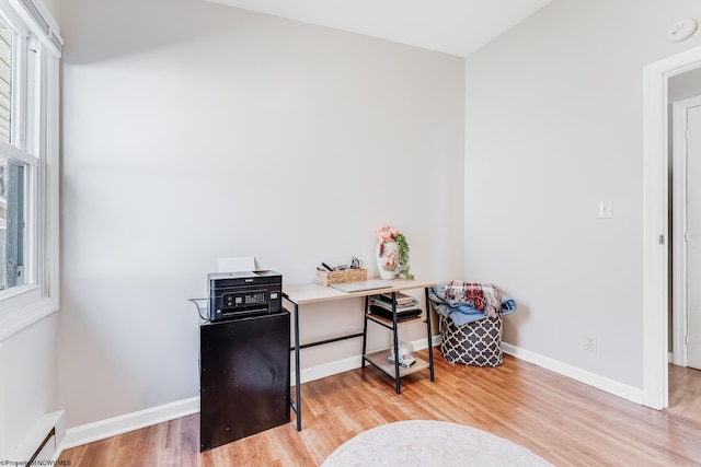 office area with light wood-type flooring, plenty of natural light, and baseboards