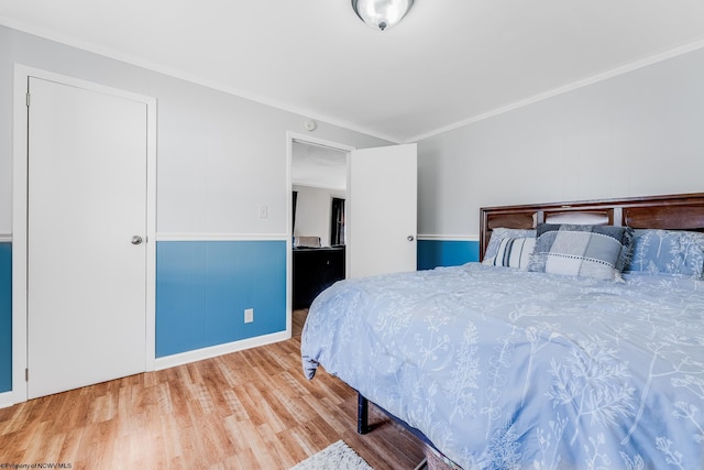 bedroom featuring wood finished floors and crown molding