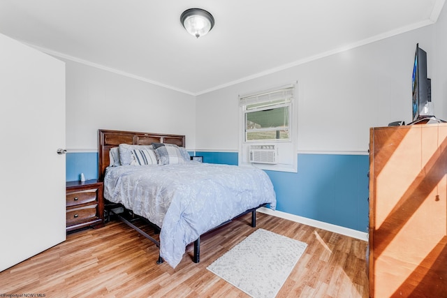 bedroom featuring ornamental molding, cooling unit, a wainscoted wall, and wood finished floors