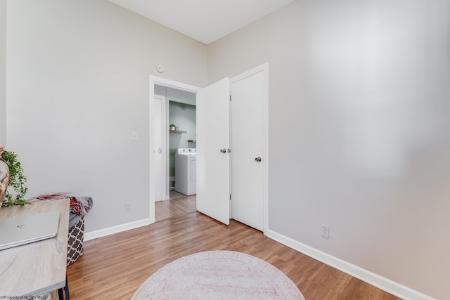 interior space featuring light wood-type flooring, washer / dryer, and baseboards