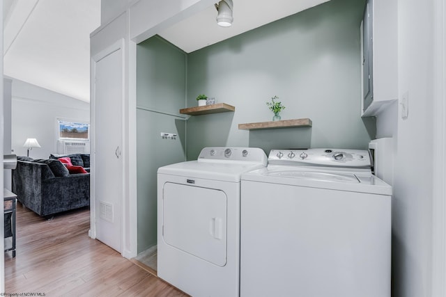 clothes washing area featuring laundry area, washing machine and clothes dryer, visible vents, and light wood-style floors