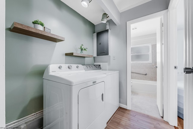 laundry area featuring washer and clothes dryer, light wood-style floors, laundry area, electric panel, and baseboards